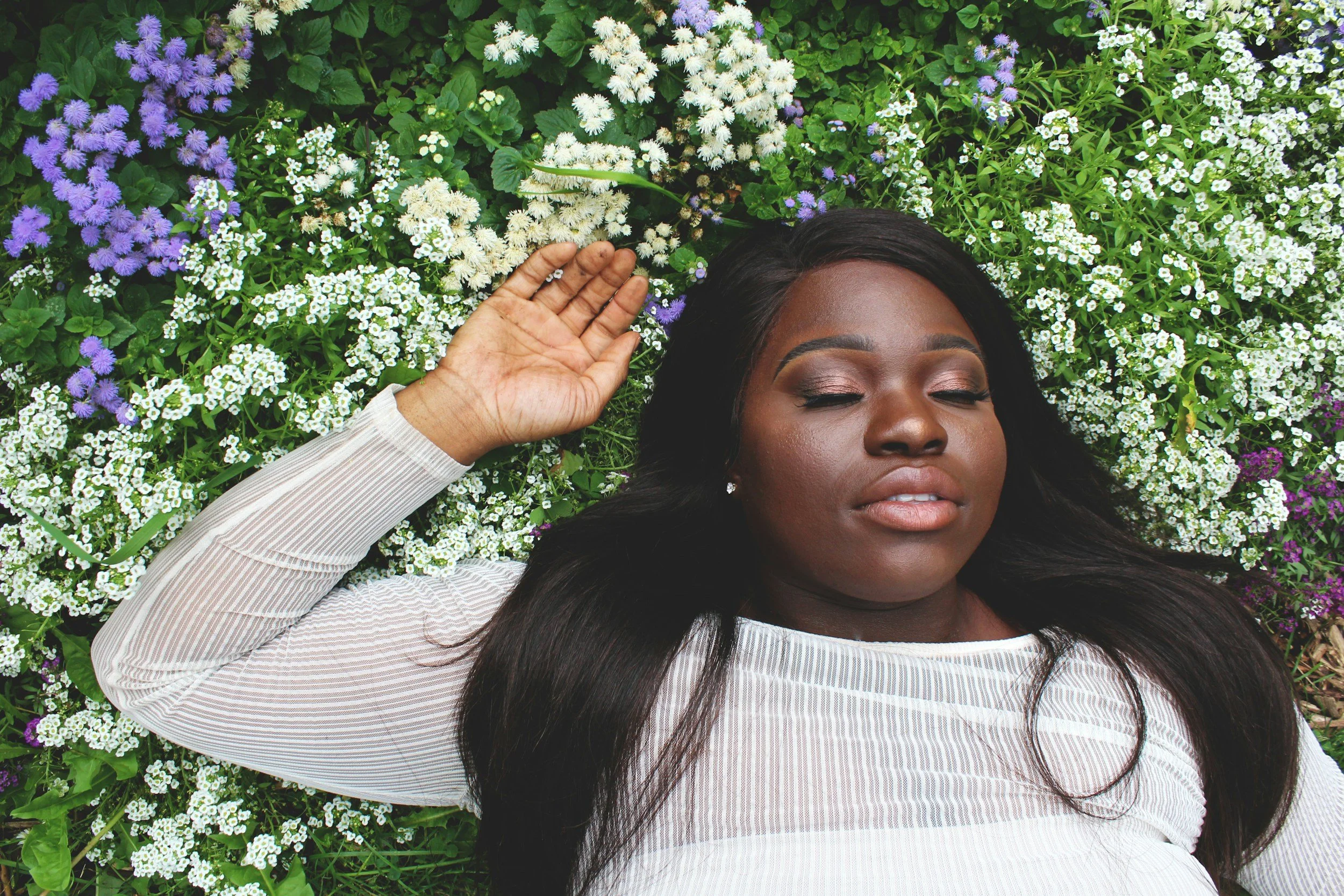 black woman relaxing in flower meadow